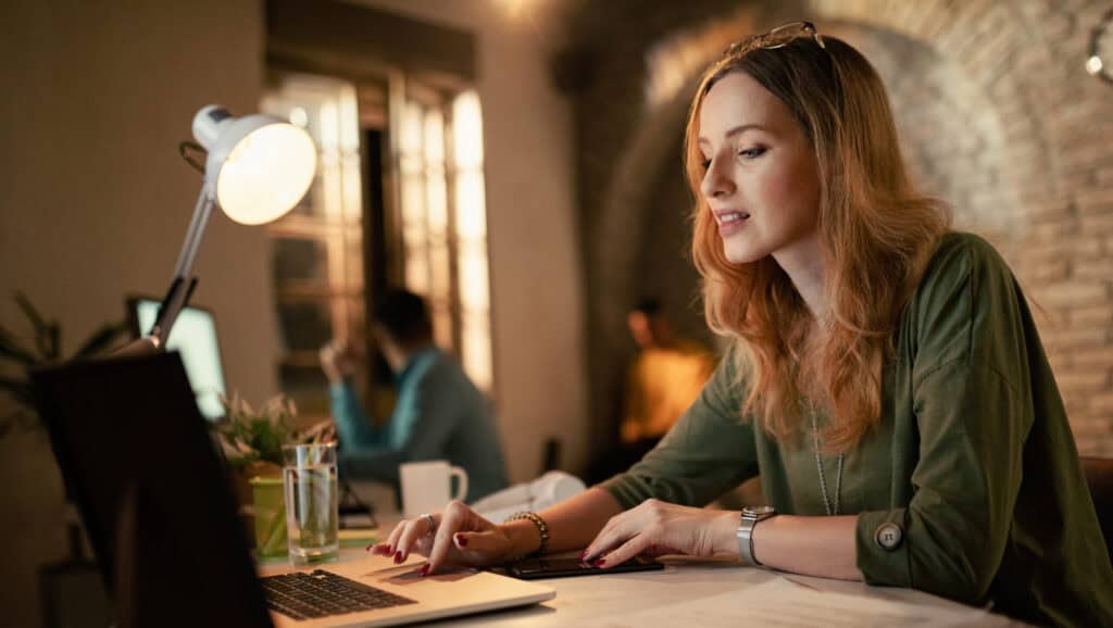 Young female entrepreneur using computer while working at night in the office.